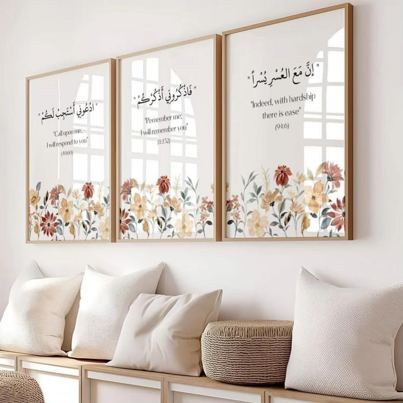 Three framed prints with floral designs and Arabic text on a wall above a sofa.